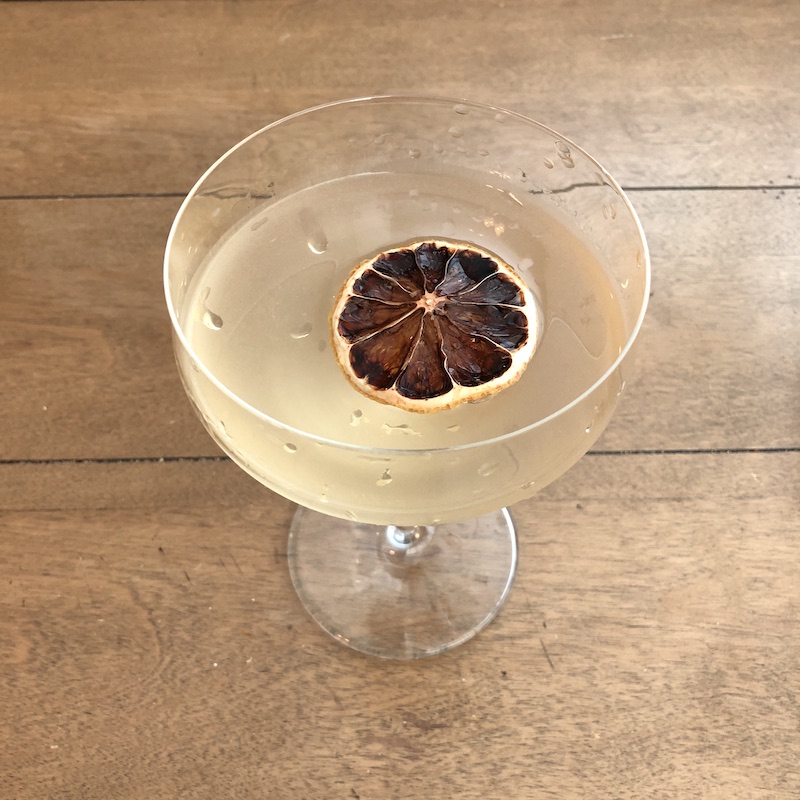 gin cocktail in coupe glass with citrus wheel garnish